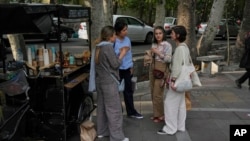 گروهی از زنان جوان در حال نوشیدن قهوه در خیابانی در شمال تهران