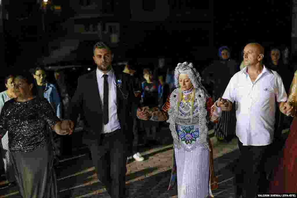 Демировиќ и младоженецот, Фејад Карадолами (втор од лево), танцуваат со гостите за време на нивната свадба.