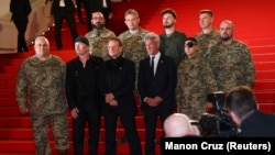 Боно, Едж та Шон Пенн разом із українськими військовослужбовцями на червоній доріжці 78-го Каннського кінофестивалю перед показом документального фільму «Боно: Історії капітуляції». Канни, Франція, 16 травня 2025 року