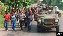 Французькі солдати проїжджають повз загін хуту, за 10 кілометрів від кордону з Заїром, 27 червня 1994 року