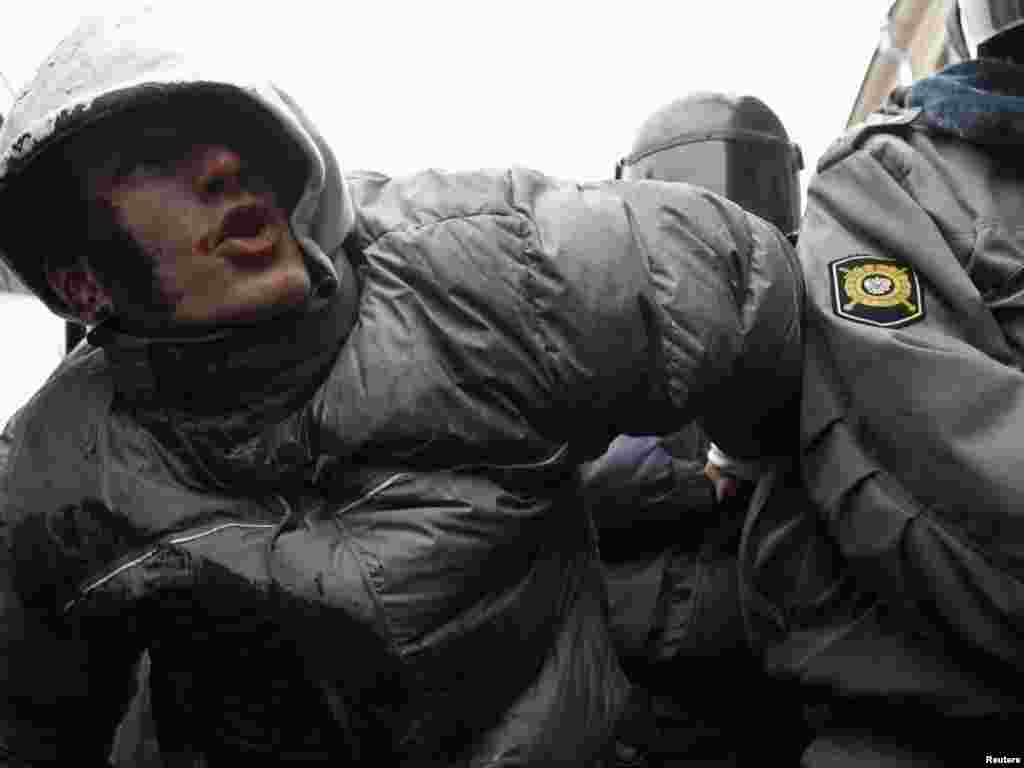 Russia -- Policemen detain an activist during a rally to protest against what activists say were violations at the parliamentary elections, in St. Petersburg, 10Dec2011