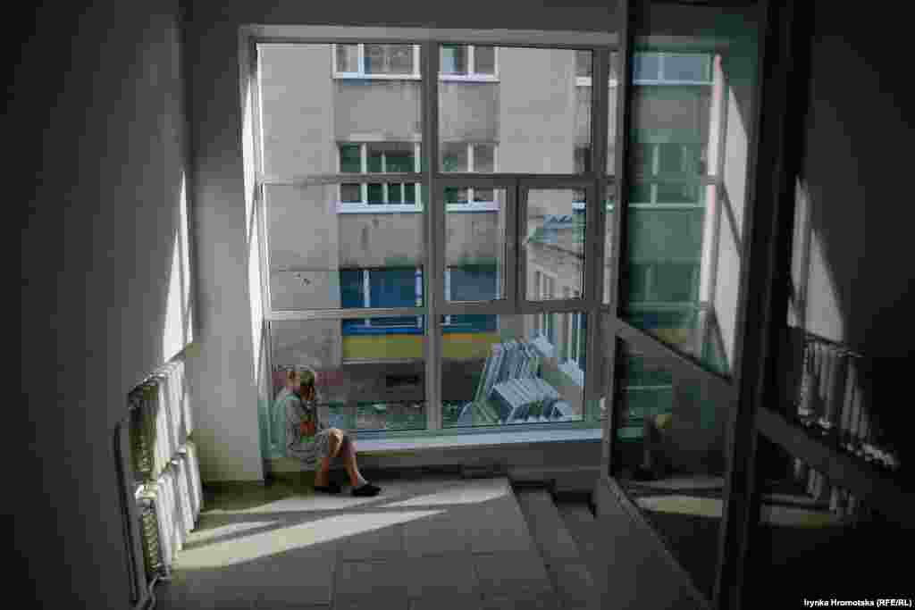 Пацієнтка розмовляє по телефону в приміщенні медичного коледжу, де тимчасово розташували відділення для хворих на коронавірус