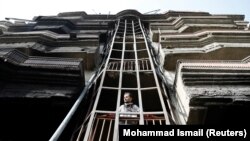 An Afghan man looks out from a damaged building after the July 28 attack in Kabul.