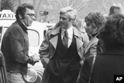 Regizorul Sydney Pollack, stânga, apare alături de actorii Robert Redford, centru, și Barbra Streisand în timpul filmărilor pentru Cei mai frumoși ani - The Way We Were, la New York, pe 28 noiembrie 1972.