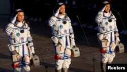 Kineski astronauti Tang Hongbo, Nie Haisheng i Liu Boming salutiraju pre poletanja u svemir 17. juna 2021. 