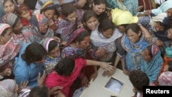 Family members mourn as they gather near the body of a relatives killed in Lahore blast on March 27.