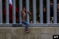 Сім'ї мігрантів із Сирії та Іраку за прикордонною стіною на польсько-білоруському кордоні неподалік від Біловежі, Польща, 29 травня 2023 року