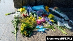 У центрі на постаменті поклали жовтий букет, перев’язаний блакитною стрічкою – у кольорах українського прапора